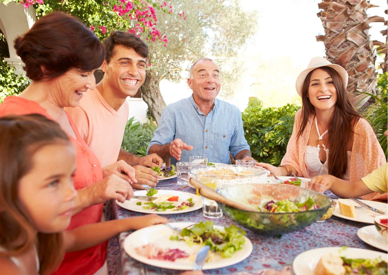 A diverse group enjoying a shared outdoor meal, highlighting Spanish family and community social cohesion