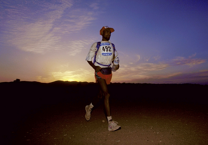 An endurance athlete running at sunset during an outdoor event, exemplifying training aligned with natural circadian rhythms