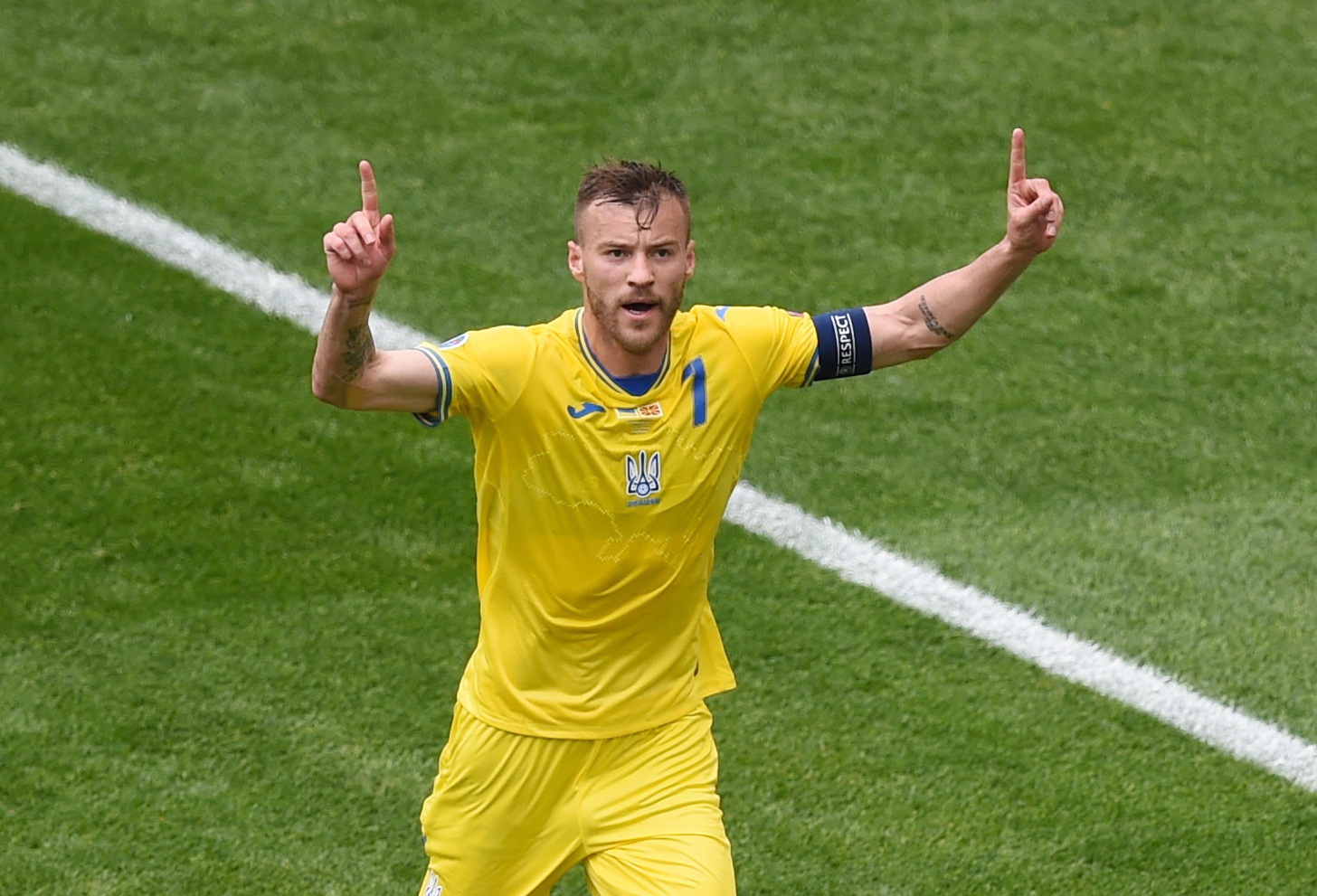 Ukrainian national football team player in celebration on the field wearing jersey number 1 and captain's armband