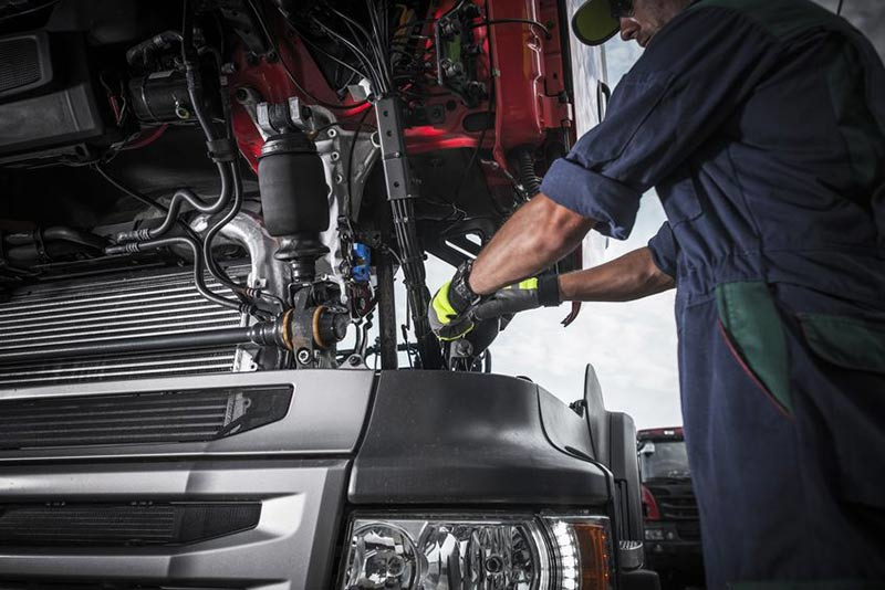 An ASE certified mechanic professionally working on a diesel truck engine, emphasizing the value of expert installation