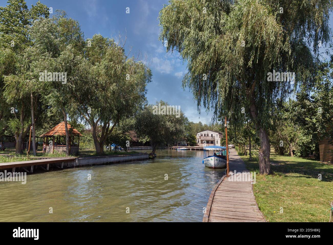 A peaceful wooden quay and boat on a river in Vilkove, Ukraine, illustrating a tranquil setting for fishing and outdoor recreation