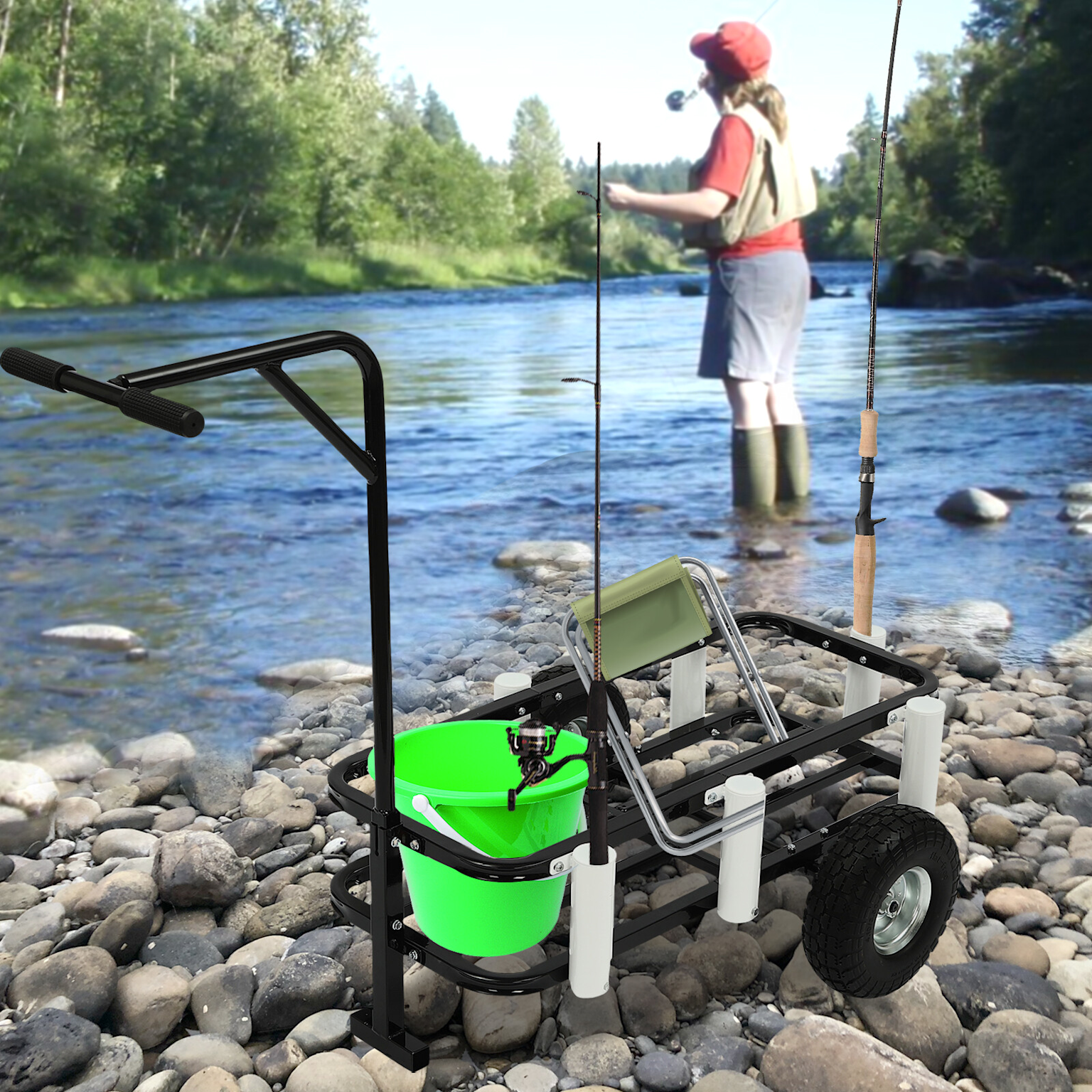 Heavy-duty fishing cart with gear on a rocky riverbank near a person fishing in a scenic outdoor setting