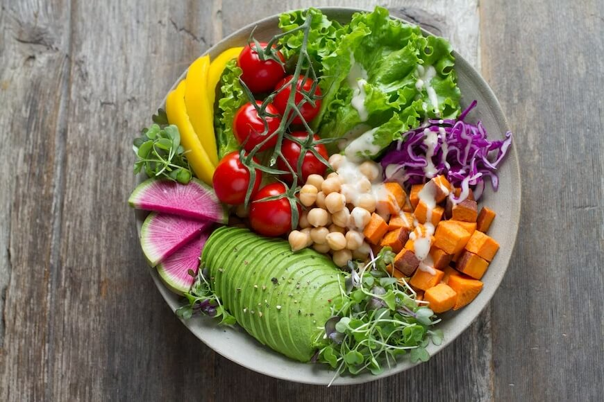 A colorful bowl of fresh vegetables, legumes, and avocado illustrating a microbiome-friendly diet for healthy aging