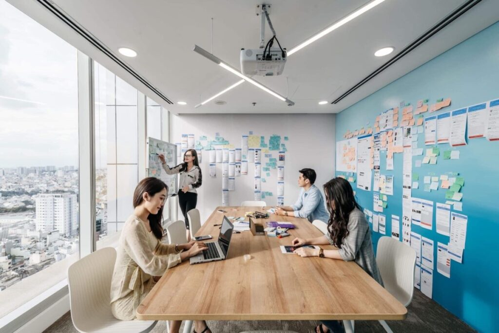 Corporate team brainstorming session with laptops and sticky notes in a modern office