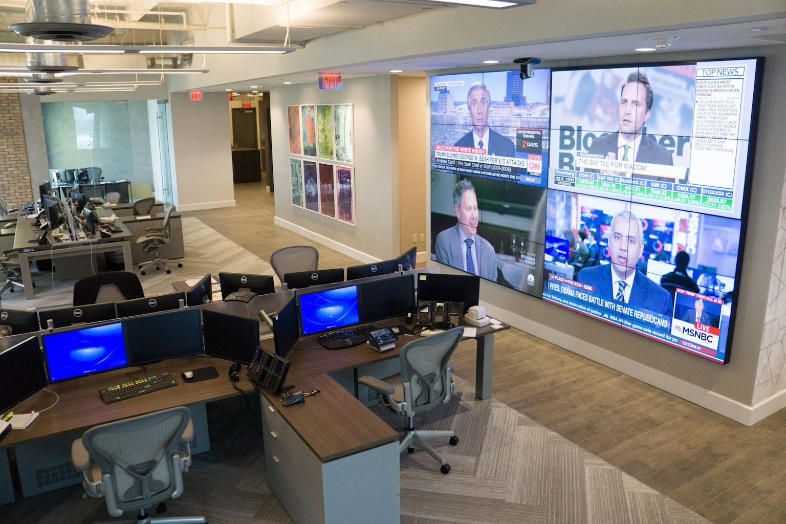 Financial trading office with multiple monitors and financial news video wall showing real-time market updates