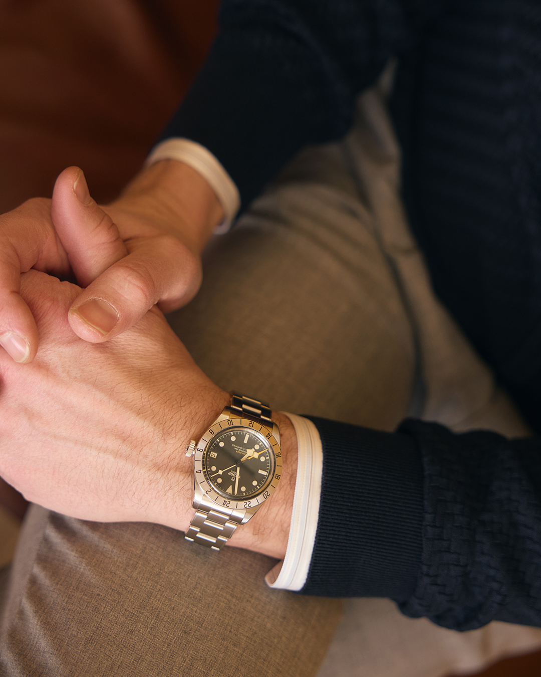 Tudor Black Bay wrist shot showing its stainless steel bracelet and classic, vintage-inspired design on a dressed-down lifestyle setting