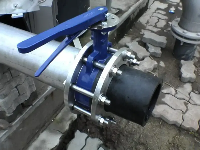 Butterfly valve installed in an industrial piping system with a blue handle for control