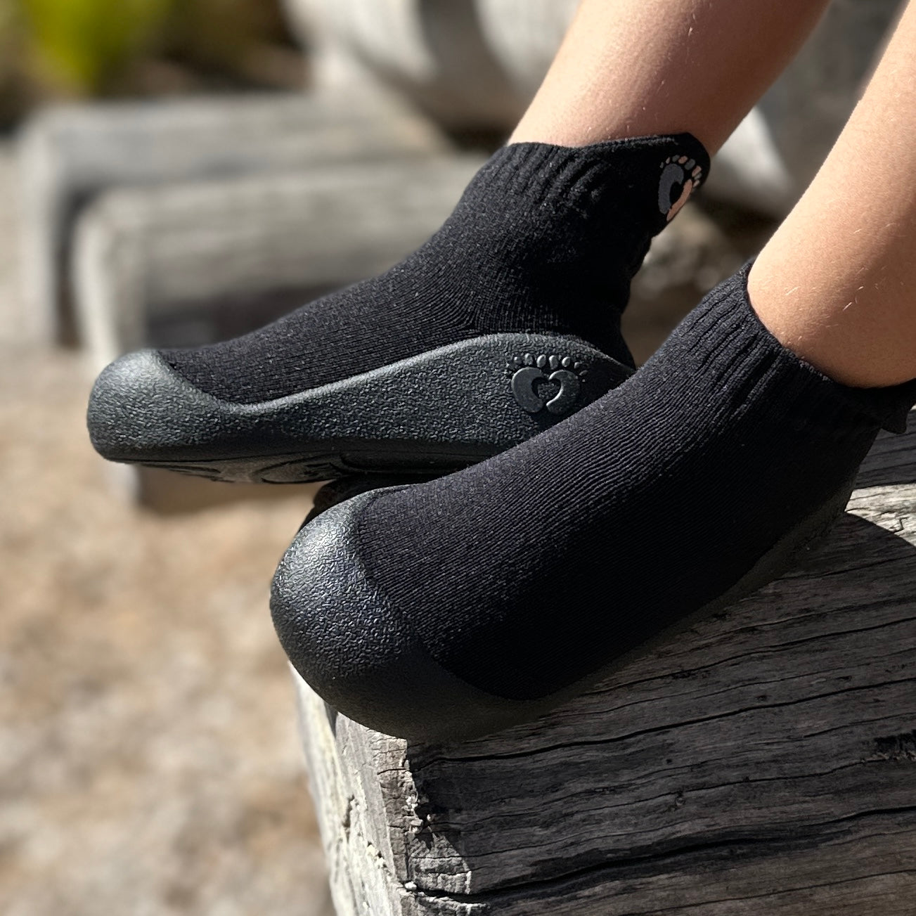 Black flexible sock-like shoes with water-resistant textured soles and breathable fabric