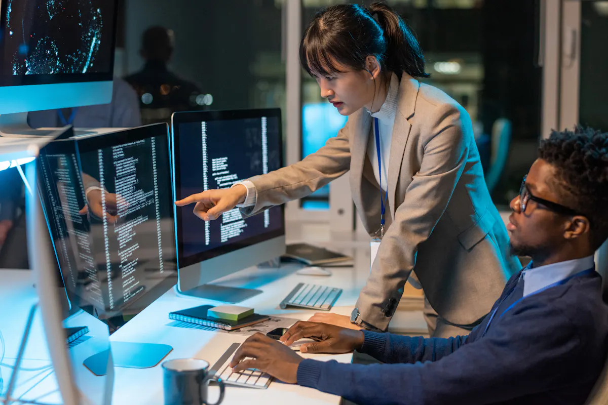 Diverse tech professionals collaborate on coding tasks in a modern office setting, illustrating the role of immigrant workers in the US technology industry