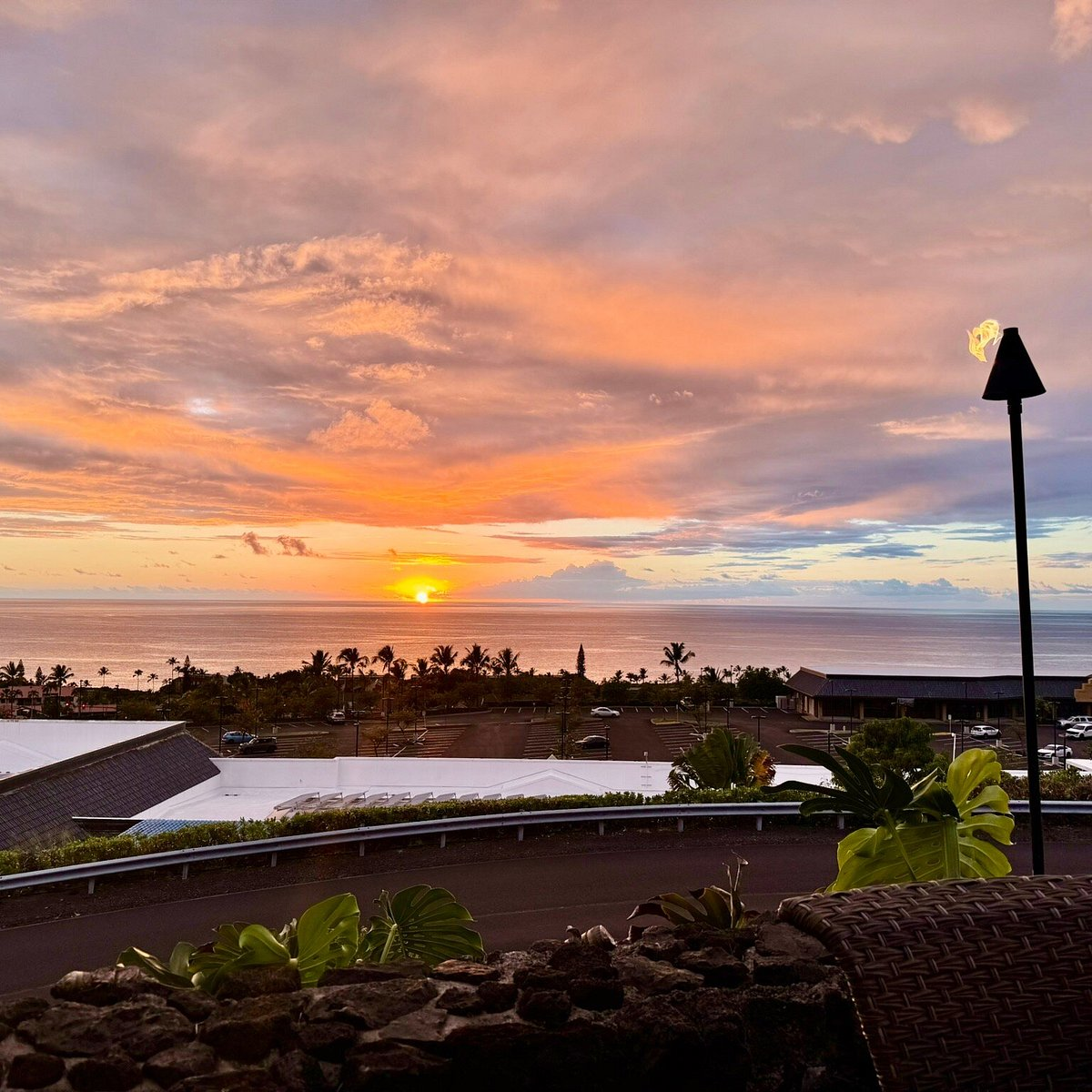 Sunset view over the ocean from an outdoor dining area at Sunset Kai Lanai on the Big Island