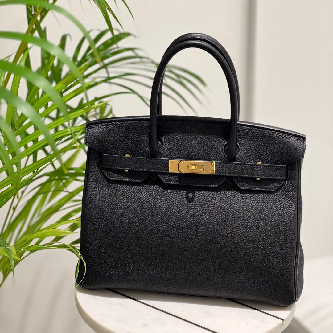 Black Hermes Birkin 30 Togo leather bag with gold hardware on a white marble table