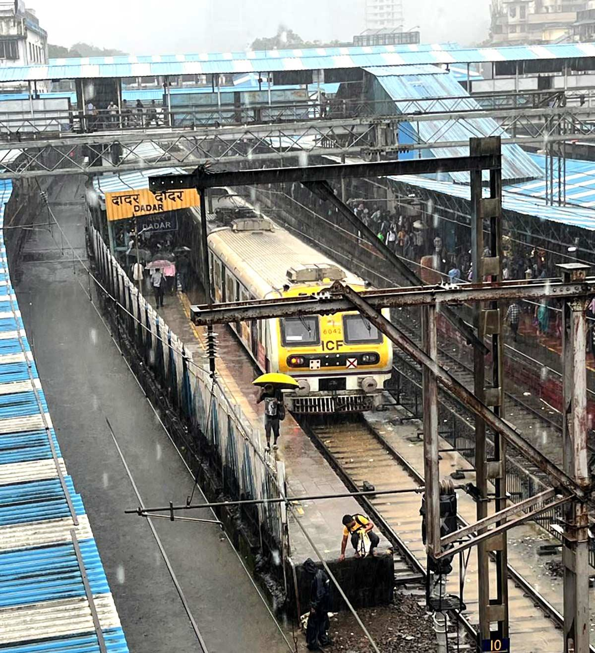 Mumbai local train at Dadar station during heavy rain, illustrating delays and disruptions caused by monsoon flooding