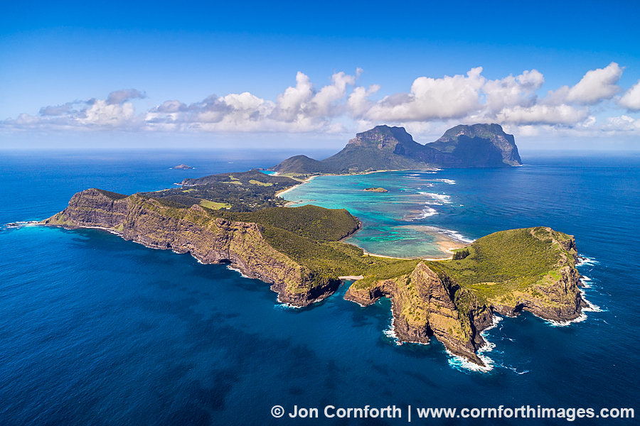 Aerial view of Lord Howe Island featuring Mount Gower and turquoise lagoons under a clear blue sky