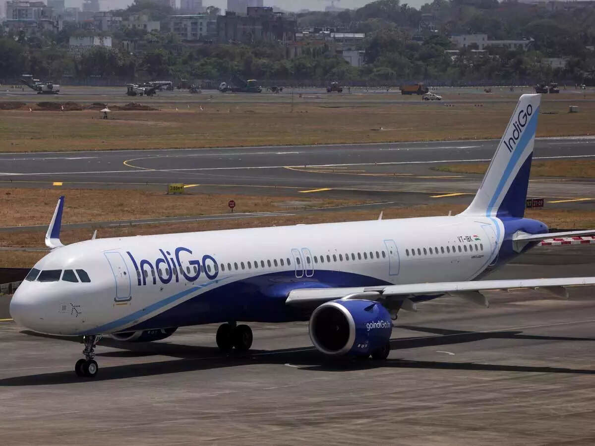 An IndiGo airplane taxiing at Mumbai airport, illustrating potential flight disruptions due to heavy rainfall and red alert