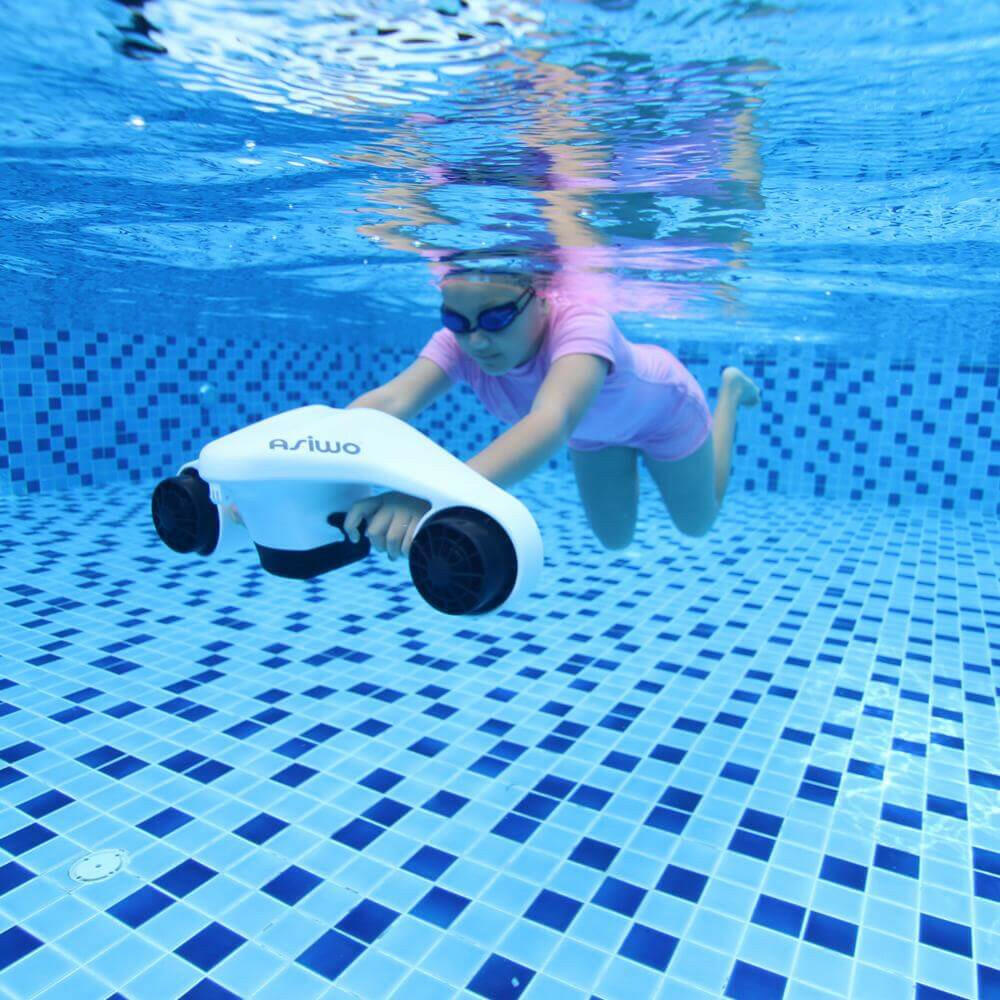 Child using a white underwater scooter in a pool, illustrating fun and safe underwater activity for kids