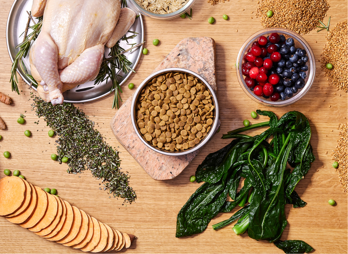 Fresh ingredients including raw chicken, vegetables, berries, and grains for nutritious dog food