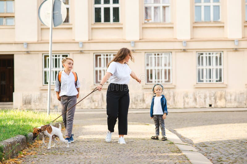 Family enjoying a walk outdoors with their dog, highlighting pet companionship and active lifestyle