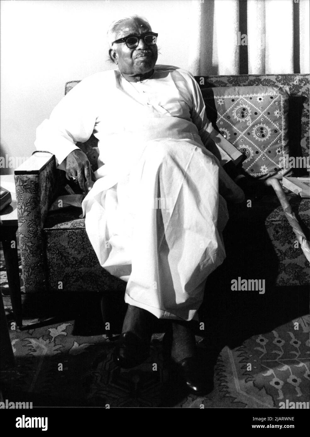 Black-and-white photograph of Jagjivan Ram seated on a sofa wearing traditional Indian attire with a cane nearby