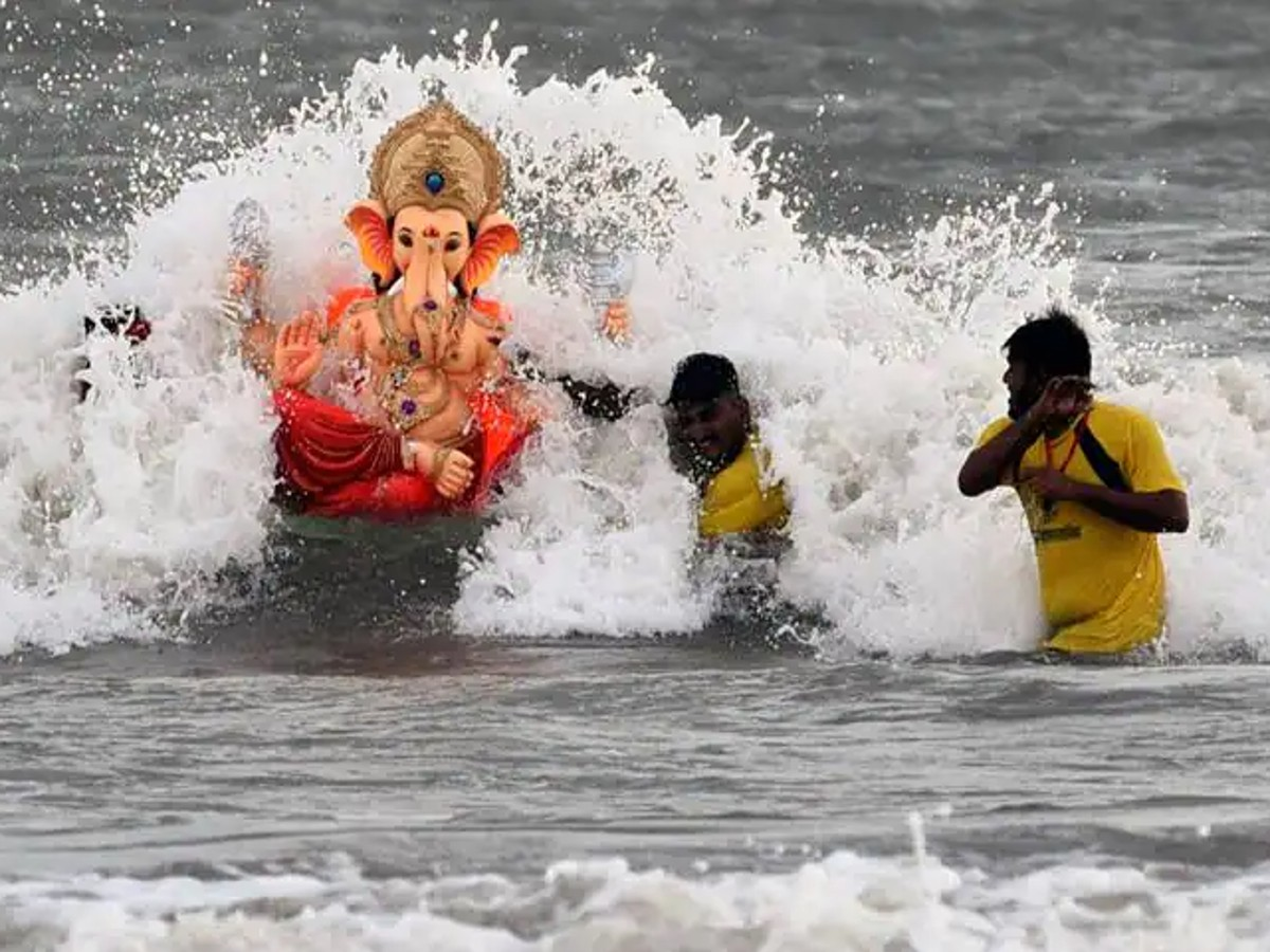 Devotees immerse a Lord Ganesha idol in water during the Ganesh Visarjan ceremony in Maharashtra, marking the conclusion of the Ganesh Chaturthi festival