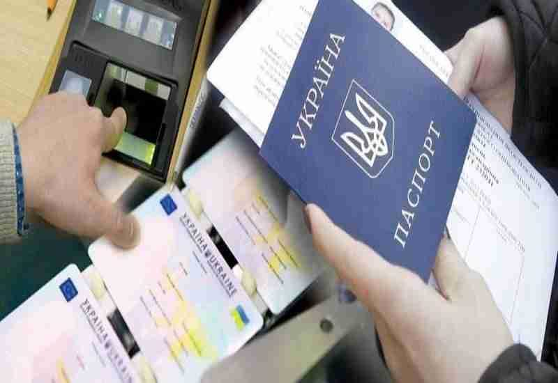 Person presenting Ukrainian passport and ID cards alongside fingerprint scanning for credit application verification