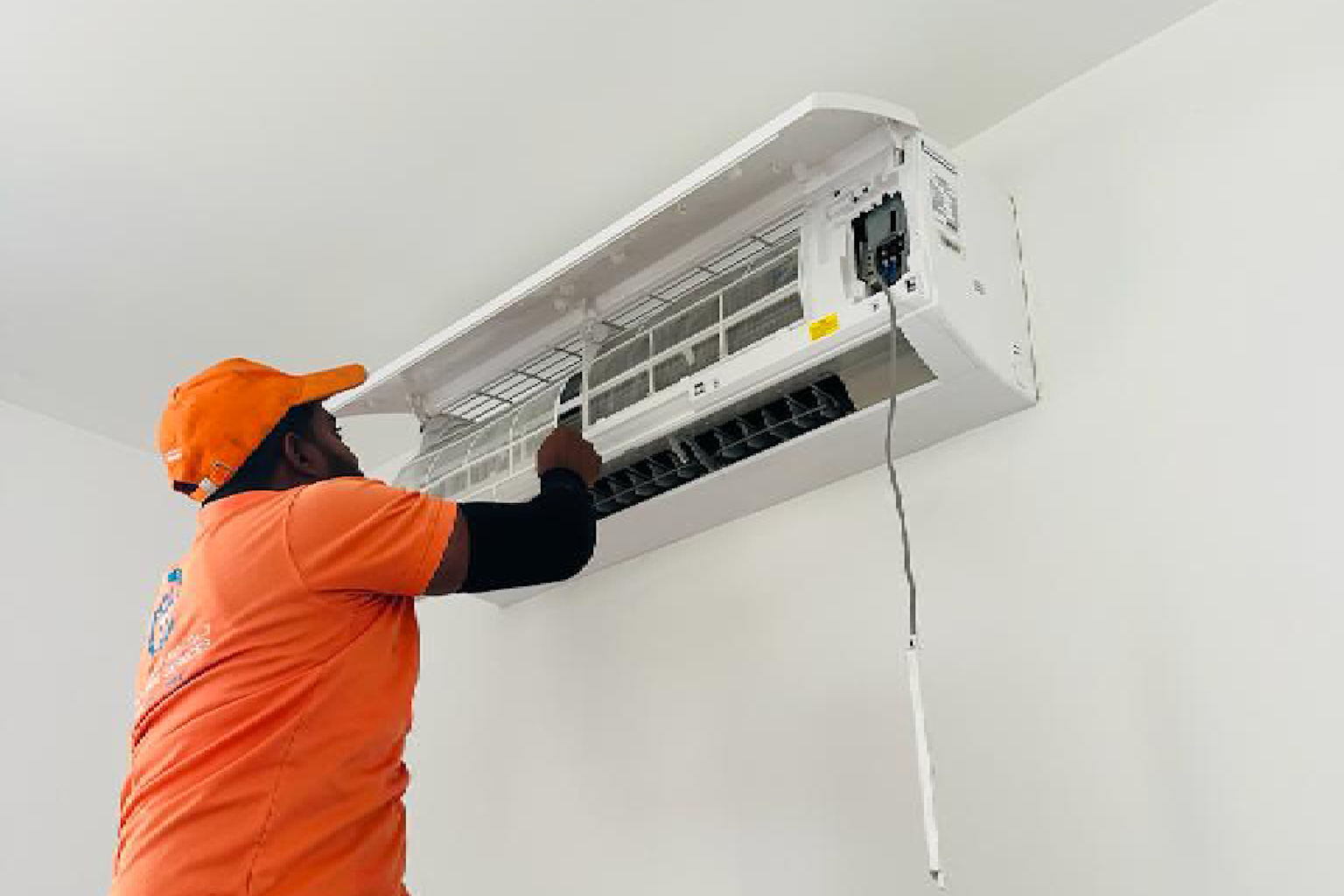 Professional HVAC technician in uniform servicing air conditioning unit