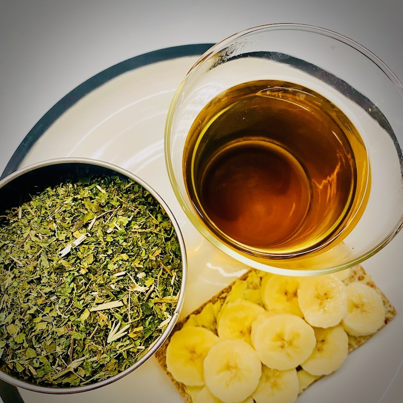 Nettle tea brewed from dried nettle leaves served with a banana cracker snack