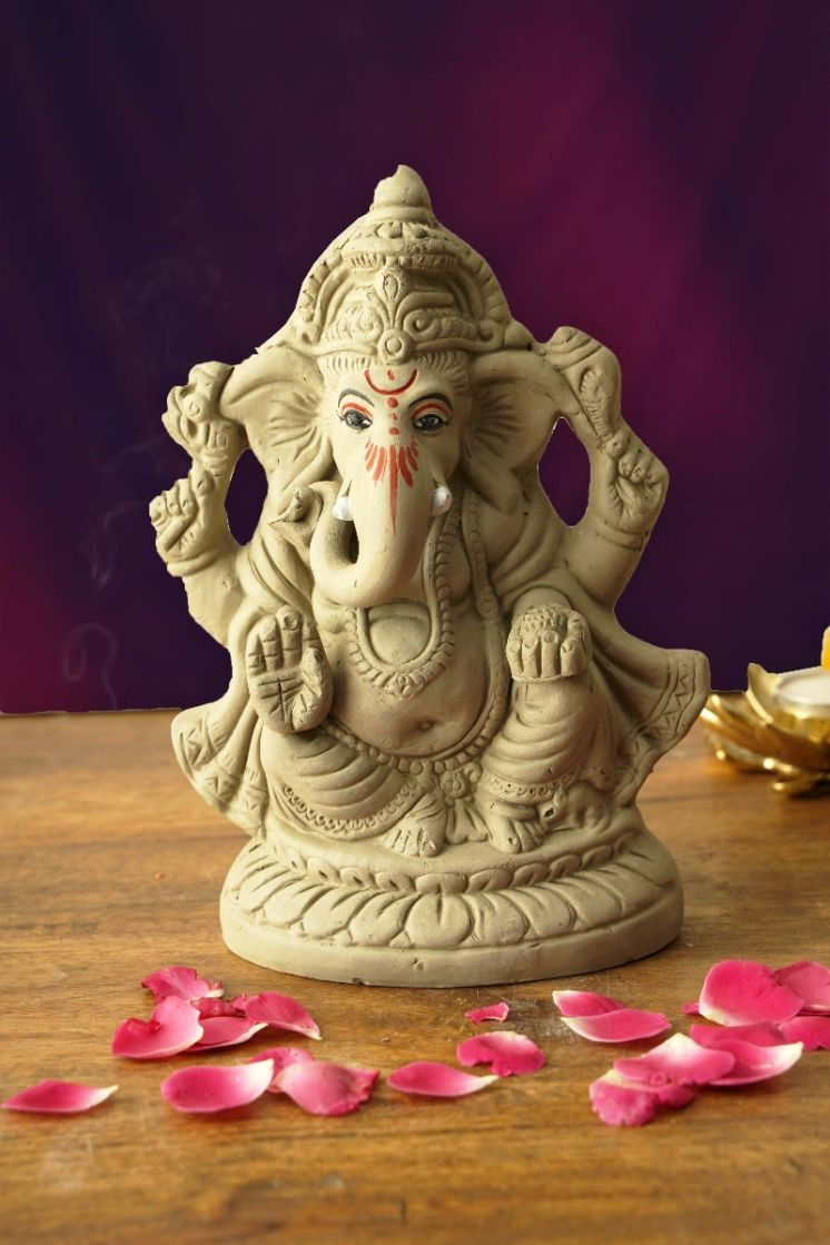 Eco-friendly clay Ganesha idol with traditional detailing and rose petal decor for festival worship