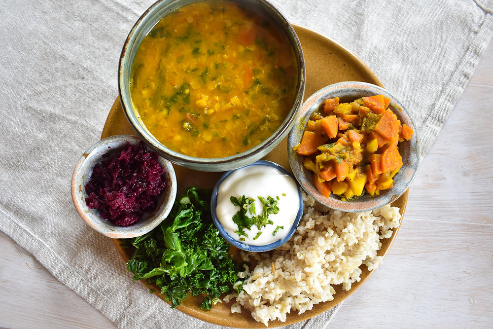 Low FODMAP Indian/Nepalese meal featuring dal, rice, cooked vegetables, yogurt, and leafy greens