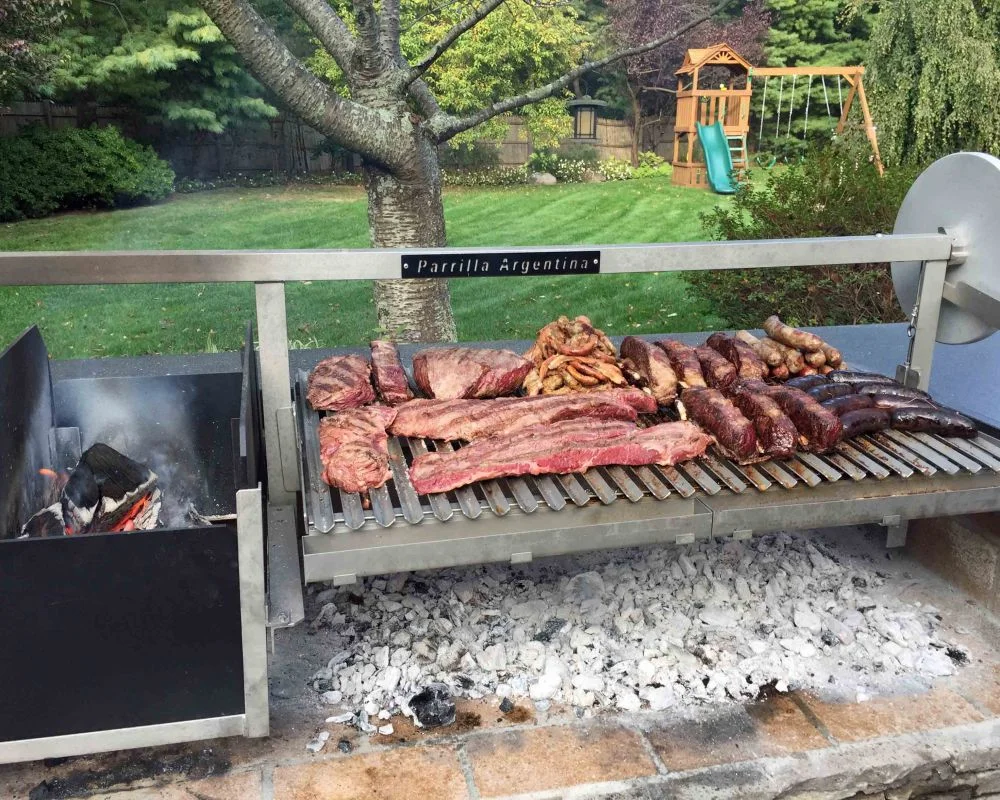 Traditional Argentine asado barbecue grill with various meats cooking over wood embers