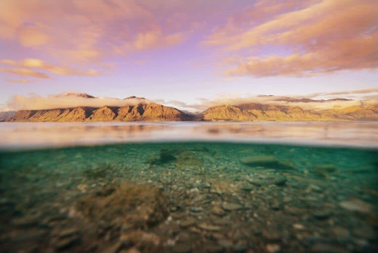 Split underwater and above water landscape photo capturing Hawaiian islands and seabed with wide-angle perspective