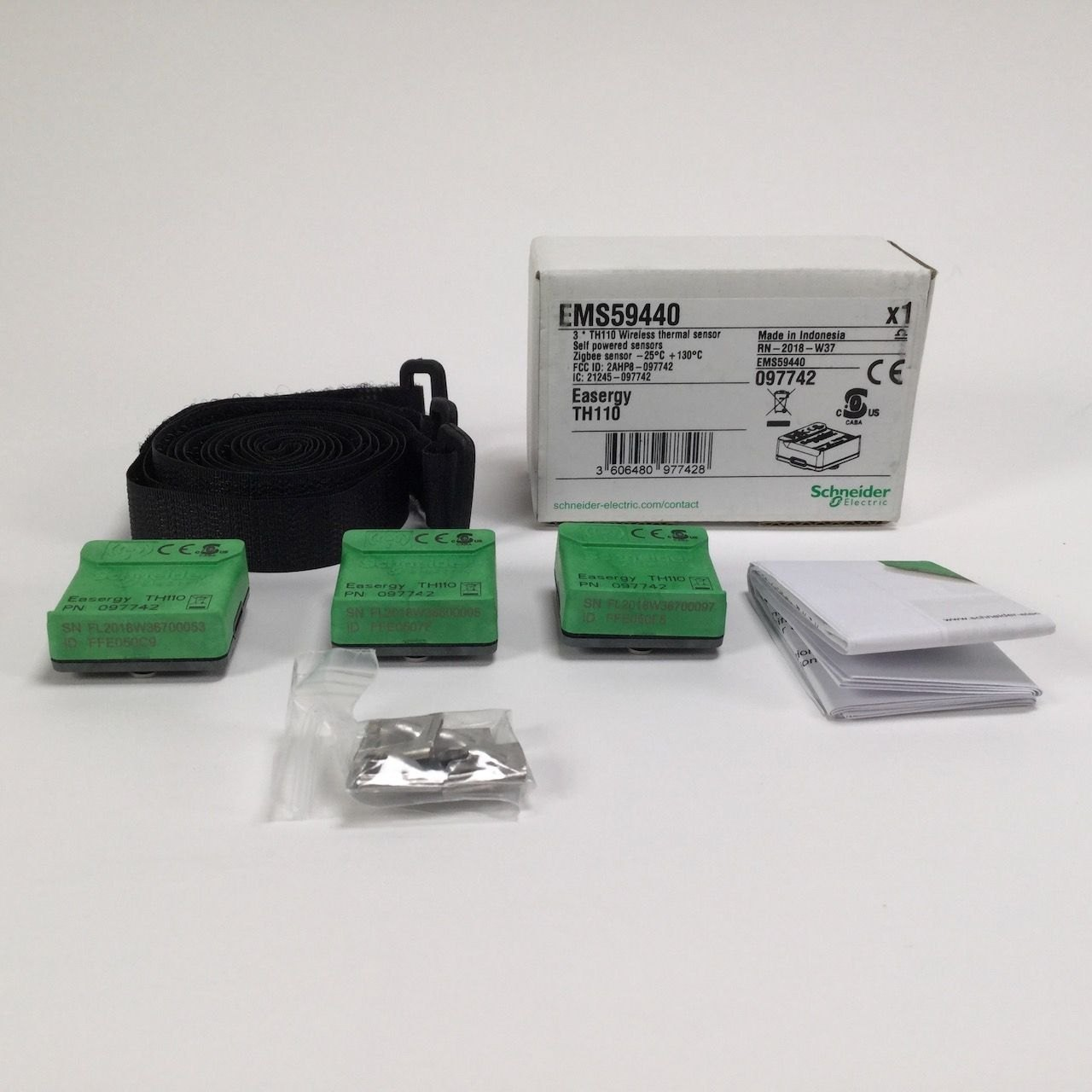 Schneider Electric Easergy TH110 wireless thermal sensor kit, including sensors, mounting strap, accessories, and manuals