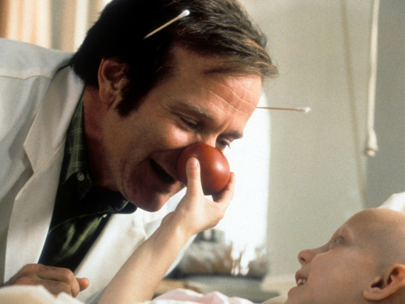 Robin Williams as Patch Adams in a medical scene highlighting humor and empathy in healthcare