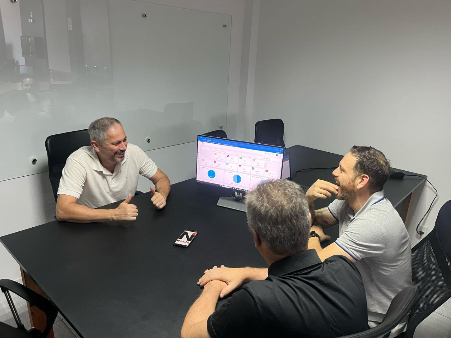 Small business entrepreneurs discussing AI implementation in a professional office setting with data dashboards on screen