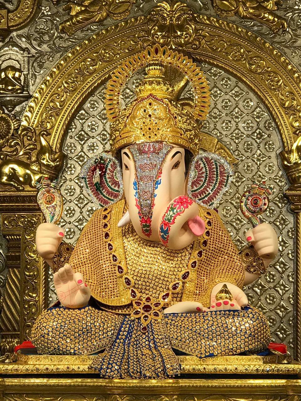 Close-up of the richly adorned golden Dagdusheth Halwai Ganpati idol in Pune showcasing intricate jewelry and decorations