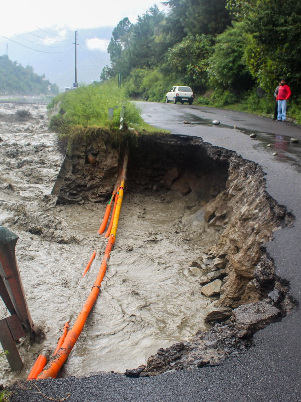 Severe flood and landslide damage causing road collapse in a hilly region, illustrating weather-related hazards in Himachal Pradesh or Jammu & Kashmir