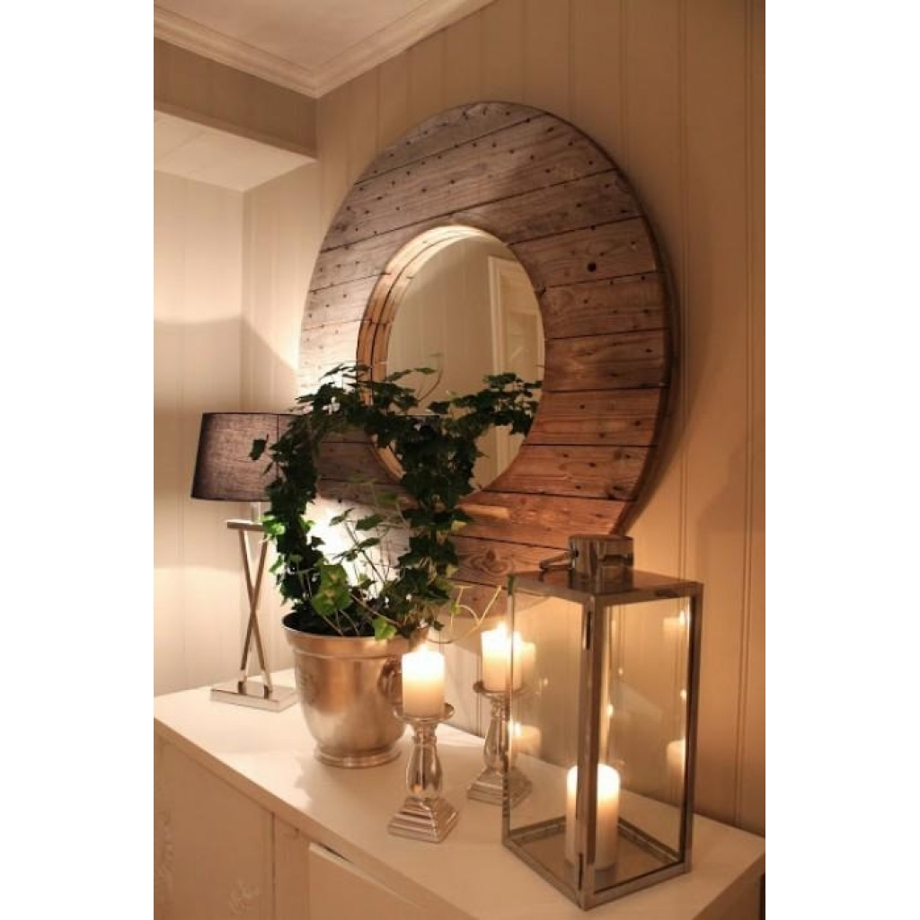 Warm and inviting entrance decor with a rustic mirror, green plant, candles, and soft lighting