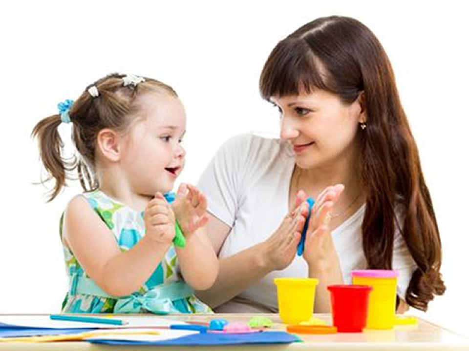 A woman and a child engaged in a hands-on ABA therapy activity using colorful modeling clay to support learning and behavioral development.