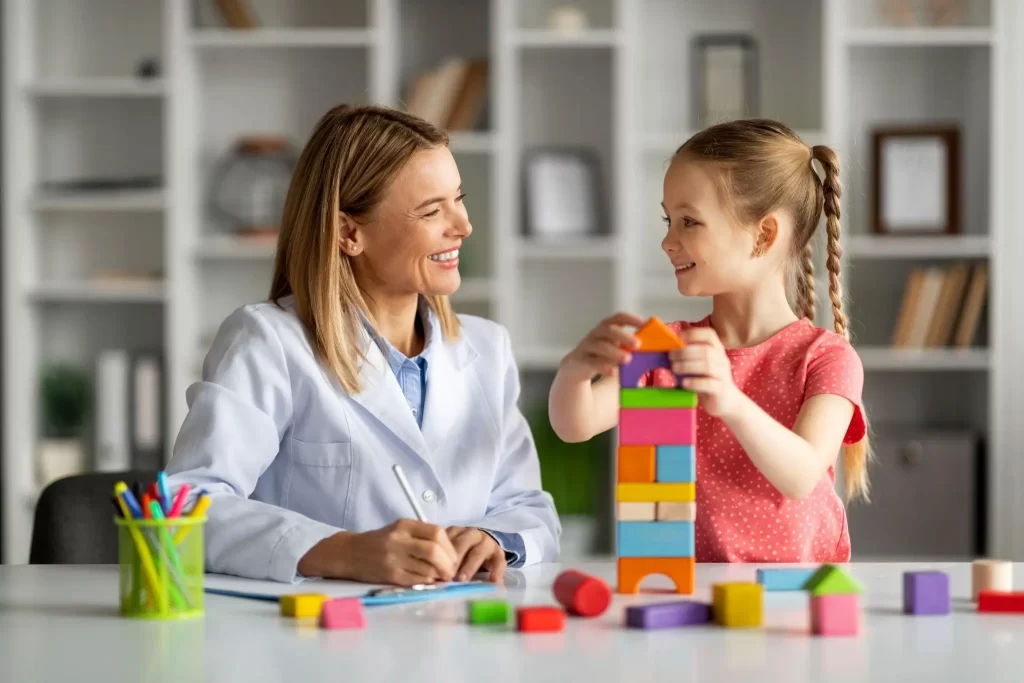 A child engages in developmental play therapy with a professional, illustrating autism intervention techniques.