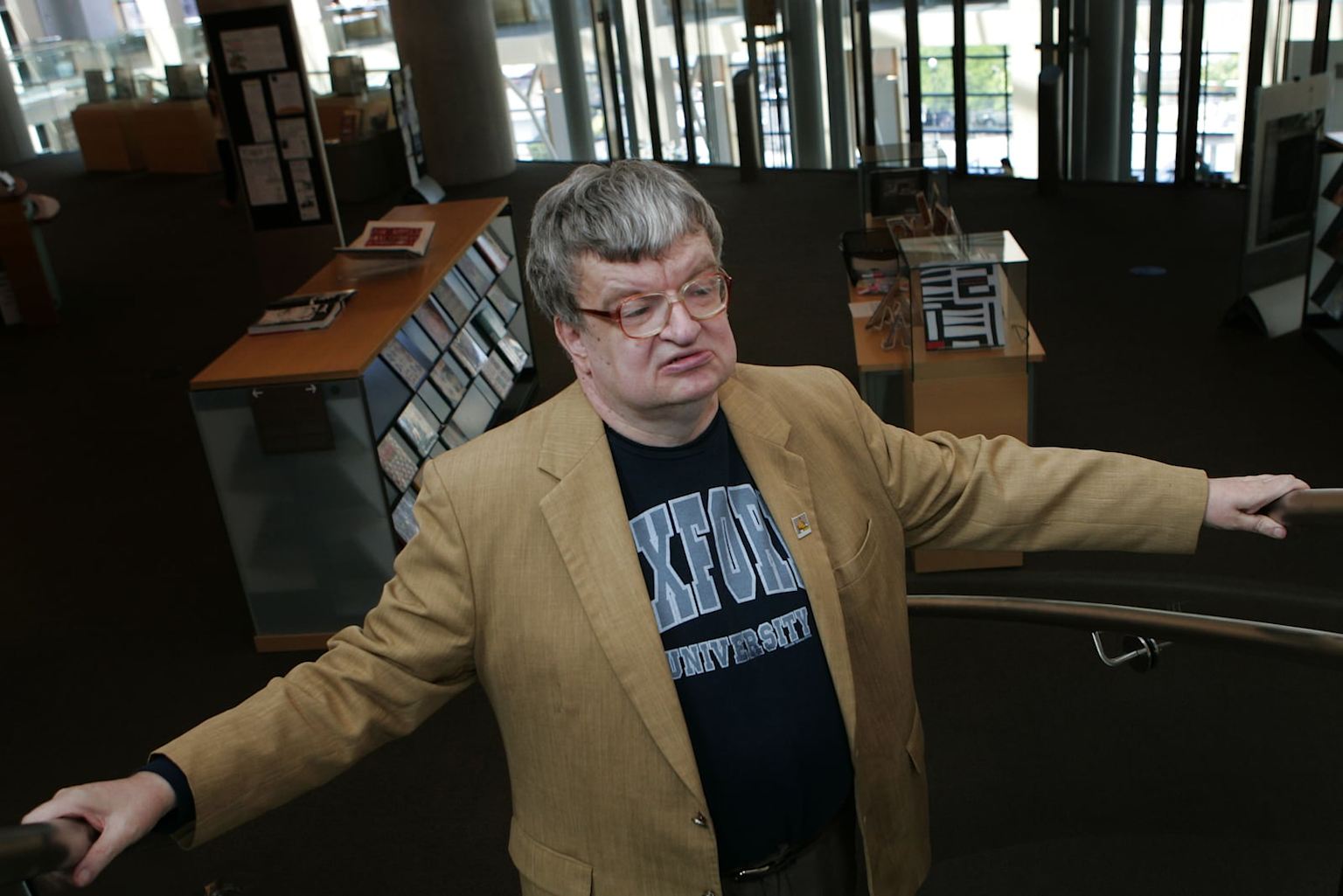 An individual wearing an Oxford University shirt, possibly representing Kim Peek, the real-life savant who inspired the movie Rain Man.