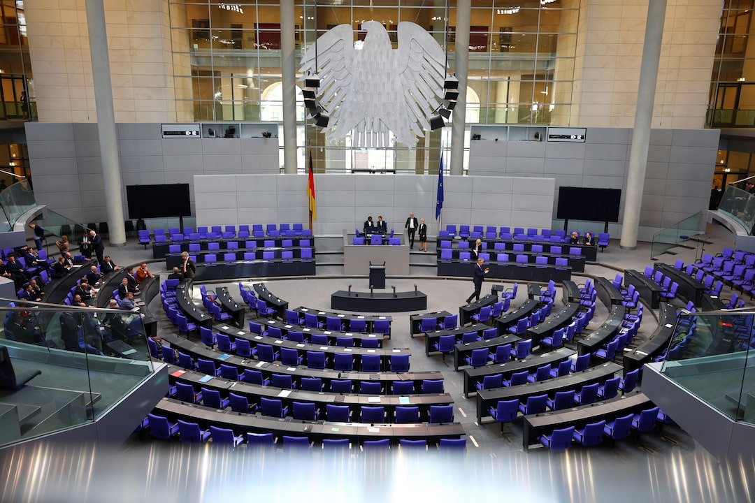 Interior of the German Bundestag parliament chamber showcasing the seating and federal eagle emblem where AfD politicians serve