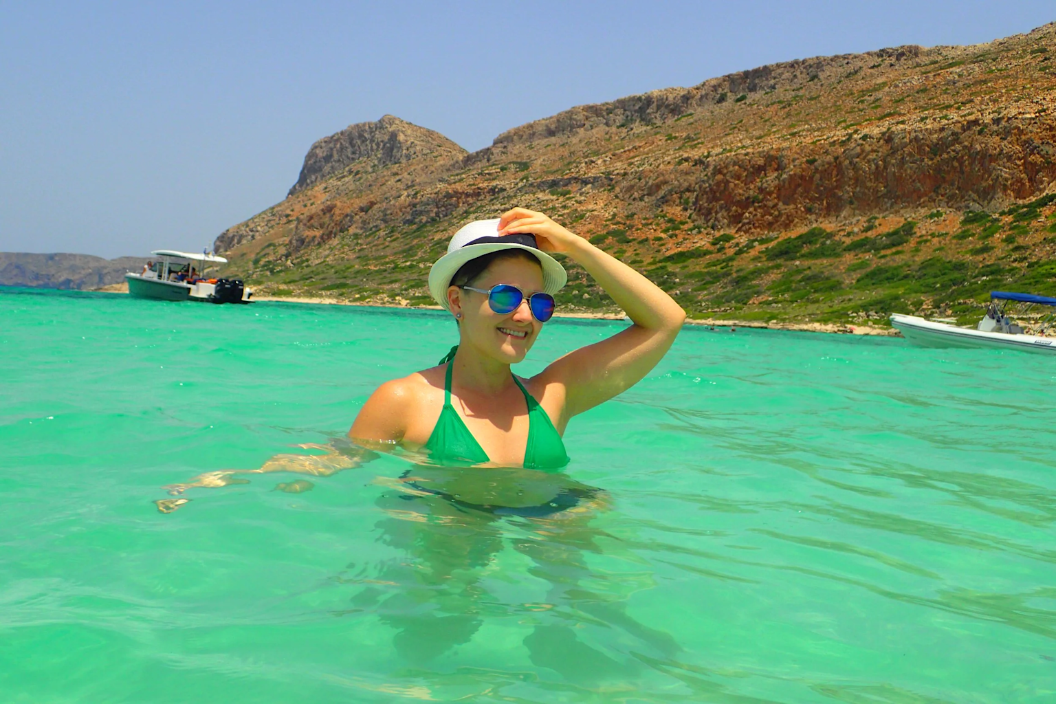 A woman enjoying the tranquil turquoise waters of Balos Lagoon beach in Crete, Greece, perfect for a peaceful and romantic solo travel experience