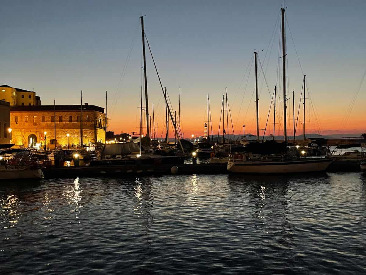 Sunset at Chania old town harbor in Crete, Greece, showcasing a romantic and peaceful sailing atmosphere perfect for solo travelers seeking rejuvenation