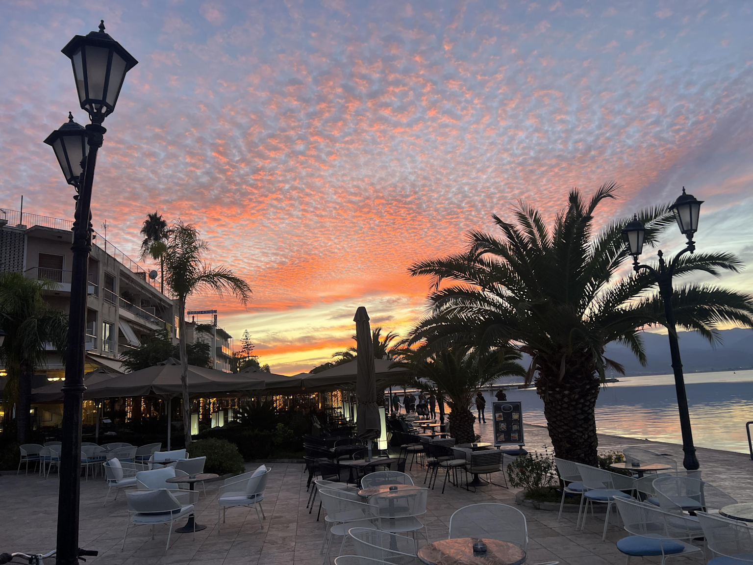 Romantic sunset over a tranquil waterfront café in Chania Old Town, Crete, ideal for solo female travelers seeking a peaceful and inspiring retreat