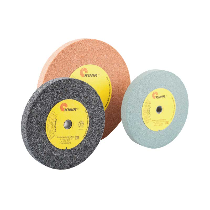 Three KINIK branded abrasive grinding wheels with yellow central labels showing specifications and branding