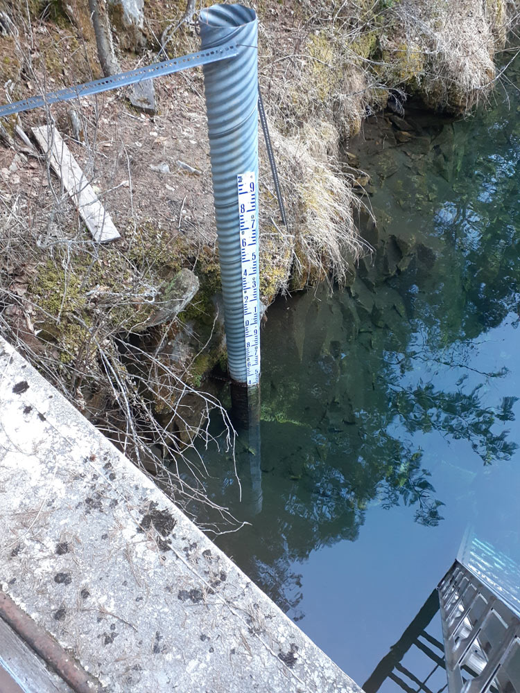Water level gauge installed on a riverbank as part of a hydrometric monitoring station for watershed monitoring