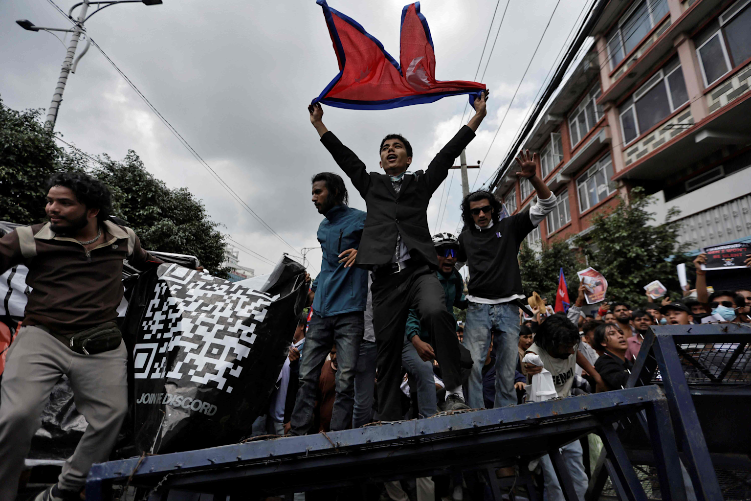 Youth protesters in Kathmandu raise a Nepalese flag amid Gen Z protests demanding political change in September 2025