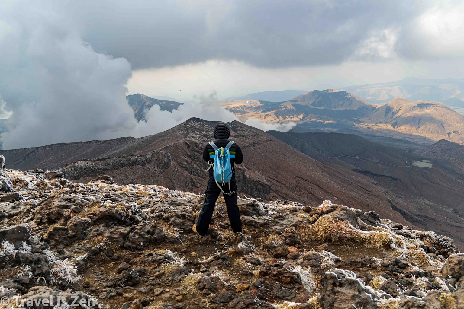 A hiker takes in the dramatic volcanic landscape of Mount Aso in Kyushu, Japan, embodying adventure and the spirit of exploration