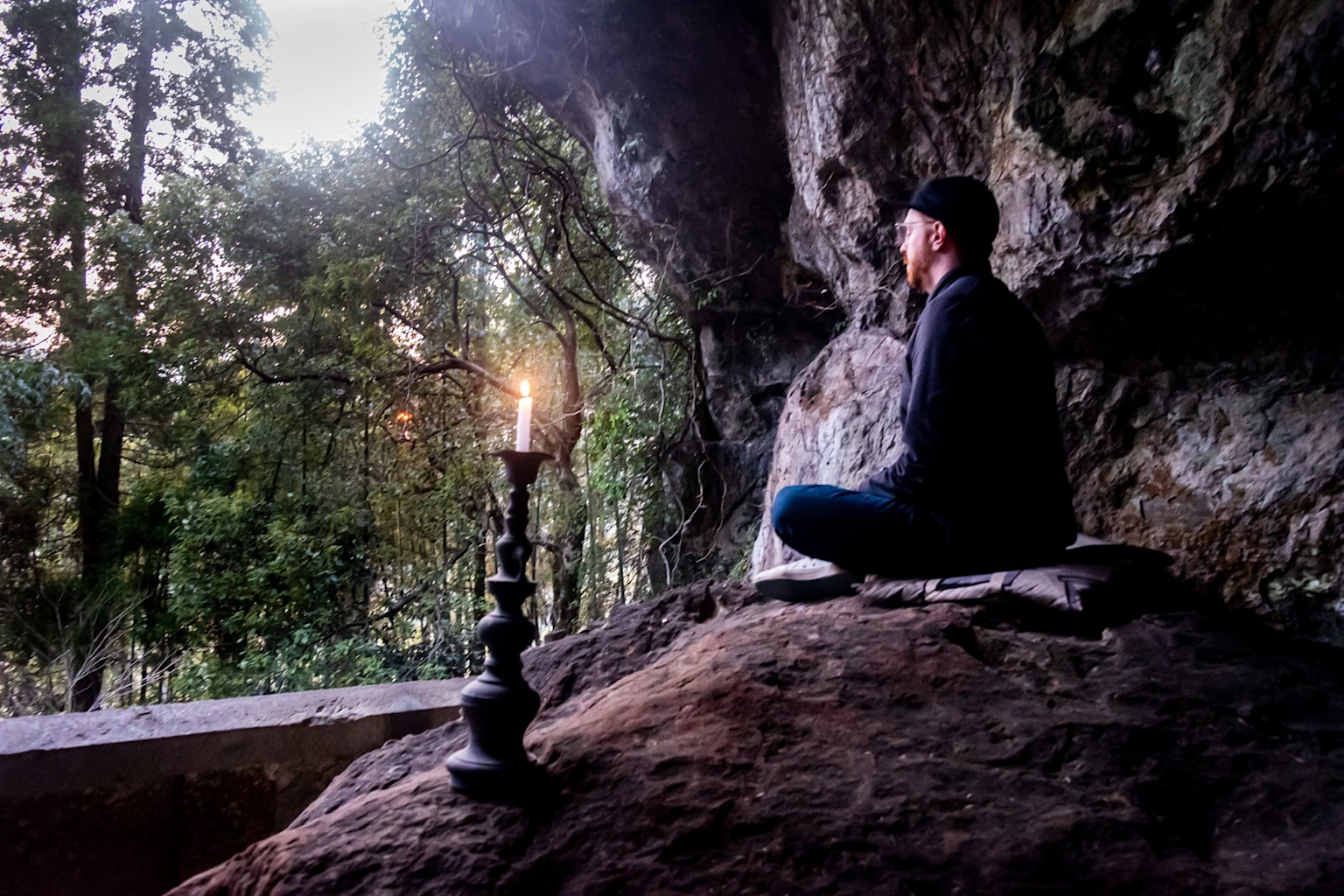 A meditative moment inside Reigando Cave, the secluded samurai meditation site of Miyamoto Musashi, showcasing peaceful solitude surrounded by nature