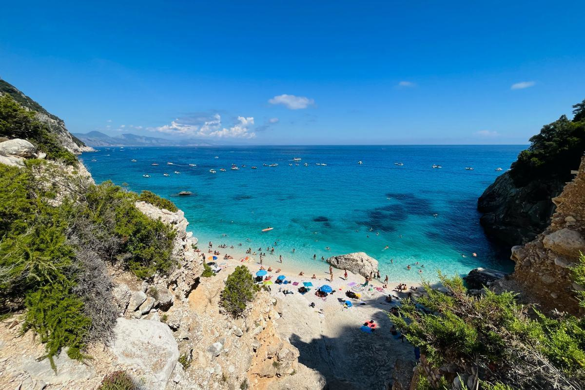 Cala Goloritzé beach in Sardinia offers breathtaking turquoise waters and rugged cliffs, perfect for an unforgettable hiking and beach adventure