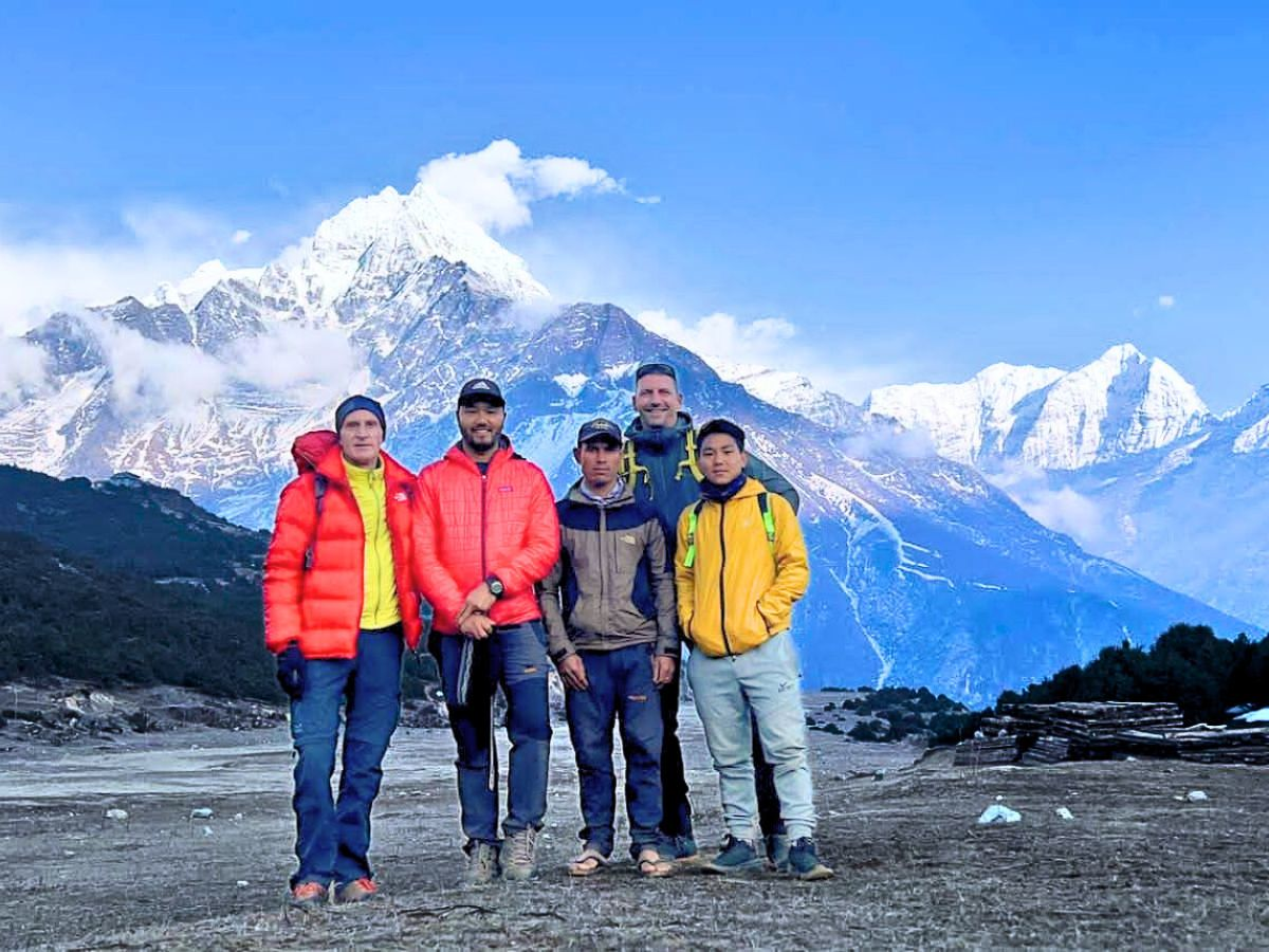 A group of men trekking in the snowy Himalayan mountains of Nepal, showcasing adventure and camaraderie in a stunning natural setting